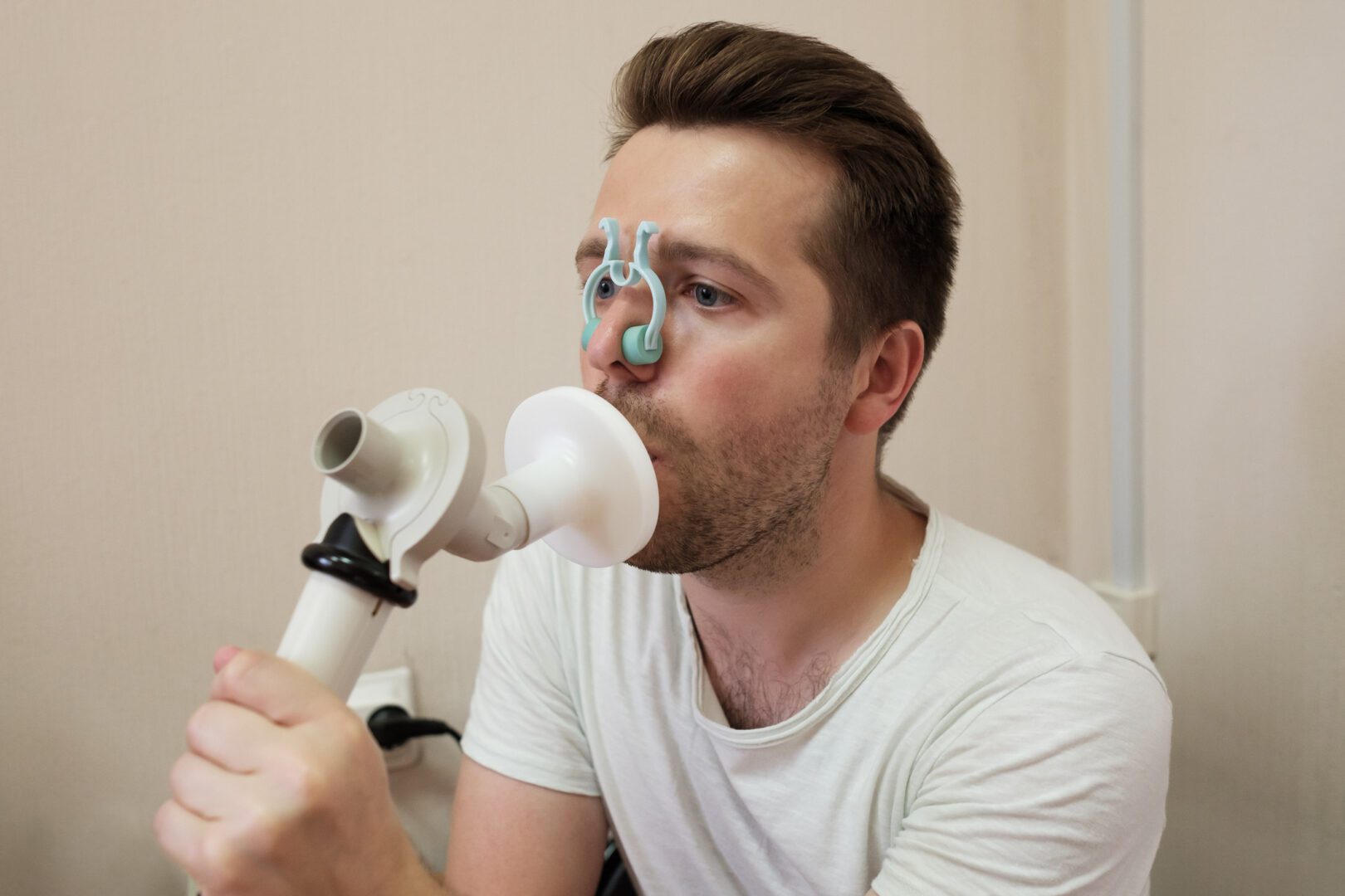 Young man testing breathing function by spirometry having health problem.