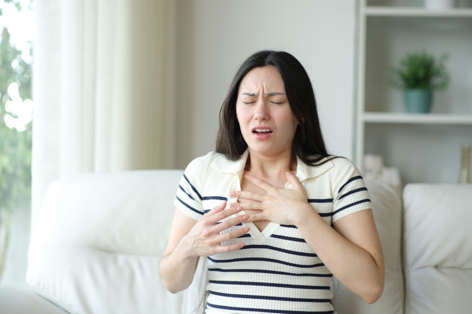 Asian woman chocking suffering asthma attack at home