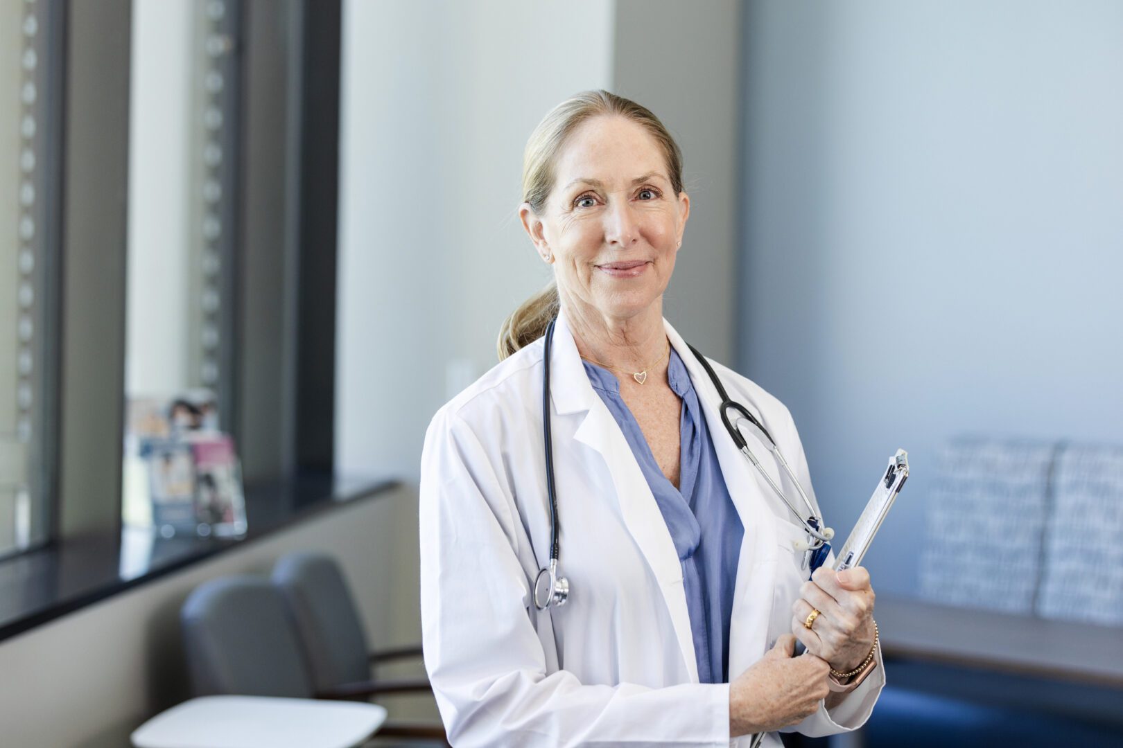 A portrait of a mature physician smiling at the camera.
