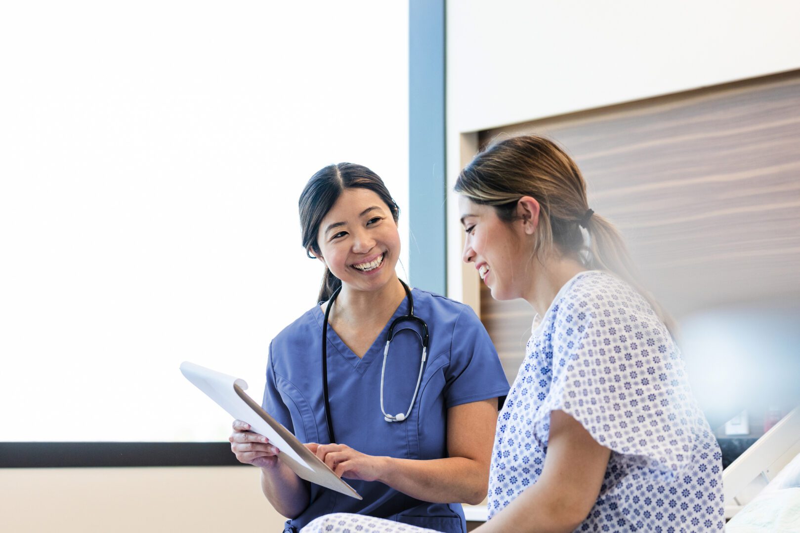 Smiling female doctor reviews patient's chart.  Healthcare and medicine, emotional support.
