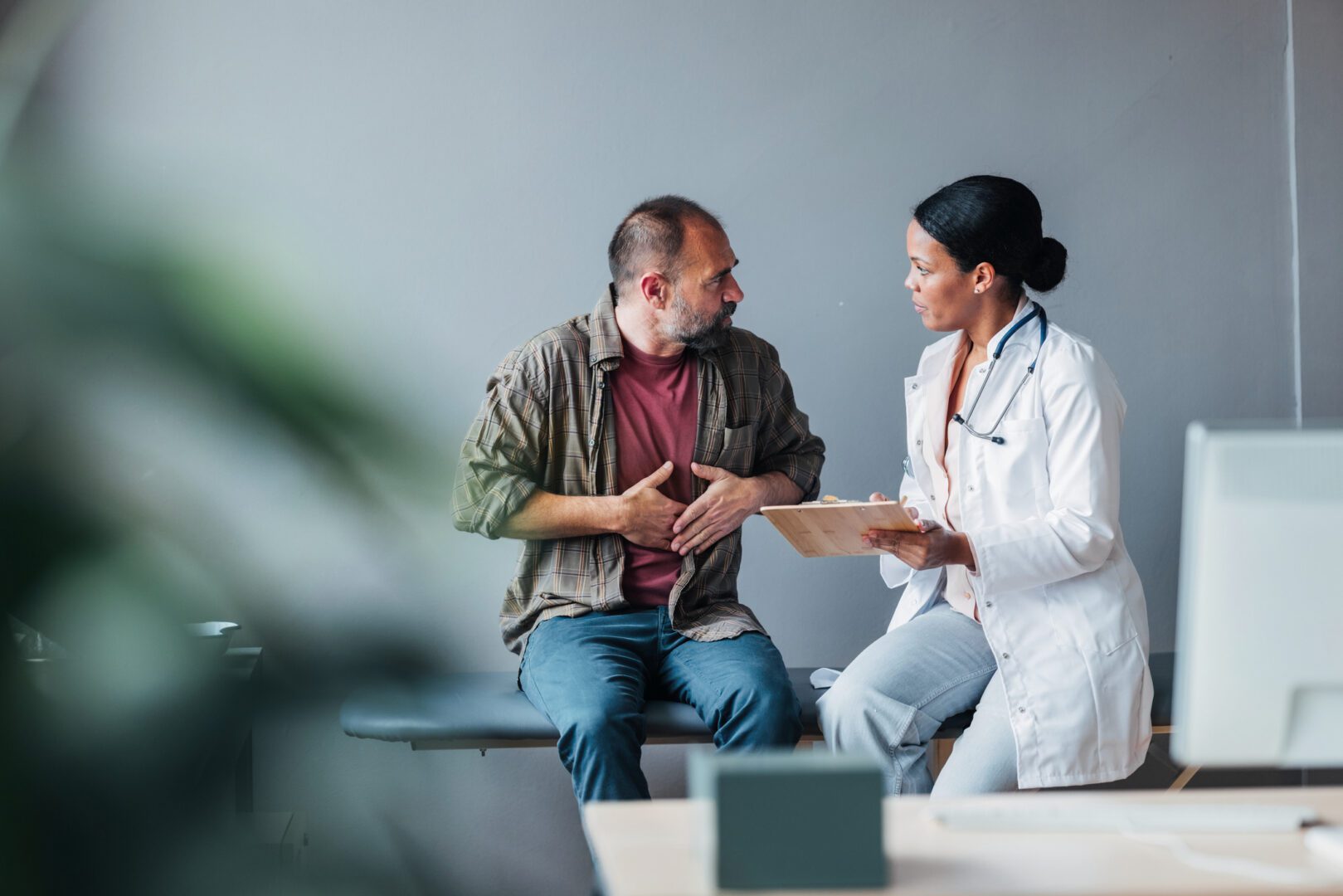 A doctor discusses health concerns with a patient in an office setting, emphasizing care and professionalism.