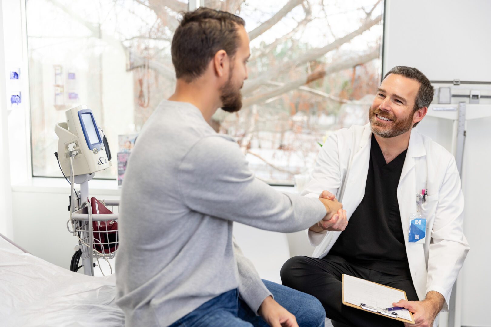 Confident doctor and patient shaking hands in medical clinic.  Positive healthcare experience.