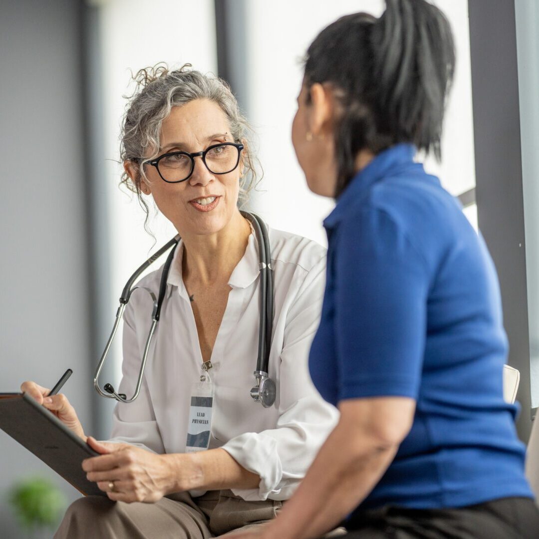 Medical practitioner discussing healthcare concerns with a patient in a modern clinic environment, ensuring comfort and understanding during their consultation.