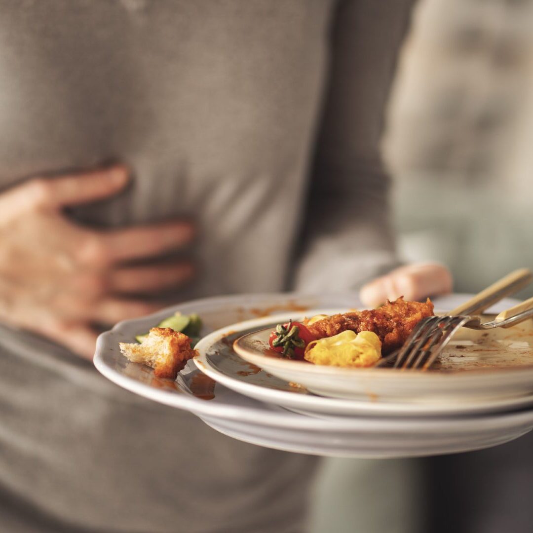 Woman with bloating and stomach pain after eating